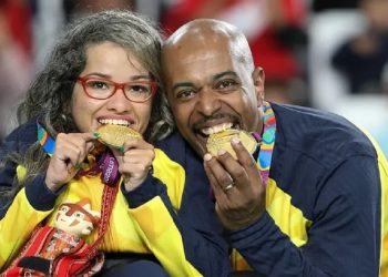 O calheiro Roberto Ferreira ao lado da atleta Evelyn Oliveira, da bocha. De costas para o jogo, ele ajusta a calha para os lançamentos da parceira. Foto: Daniel Zappe/EXEMPLUS/CPB