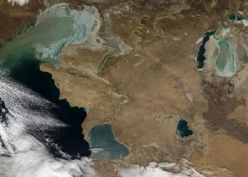Imagem espacial mostra o Cáspio parcialmente coberto por nuvens. À direita, o que resta do Aral, fragmentado em duas partes.NASA