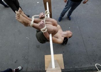 Voluntário demonstra um método de tortura conhecido como 'Pau de Arara' durante manifestação em memória dos mortos, torturados e desaparecidos durante a ditadura militar no Brasil (1964 - 1985), em frente ao Museu de Arte de São Paulo (MASP), 1° de abril