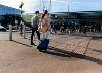 Descrição da Imagem (ALT) - Um casal caminhando em direção ao aeroporto Fonte: freepik