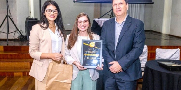Amabily Fruttos e Rafaela Buono, técnicas do Observatório Social em Foz do Iguaçu, recebem o prêmio do presidente da Rede OSB, Jean Pedroso – foto: Divulgação/OSB