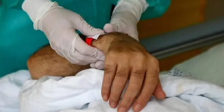 Una enfermera sostiene la mano de un enfermo de la covid-19 en un hospital en Berlín FABRIZIO BENSCH (REUTERS)