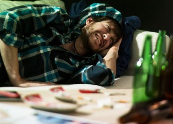 Young student having terrible headache after party