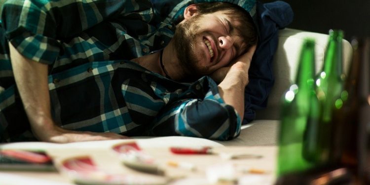 Young student having terrible headache after party