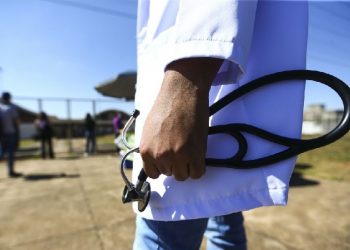 Profissional de saúde com estetoscópio na mão