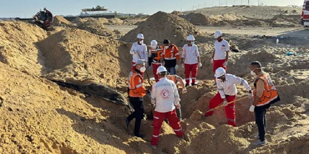 Equipes do Crescente Vermelho e da Defesa Civil palestina escavam em vala comum em busca de corpos dos socorristas (Jonatthan Whittall/X)