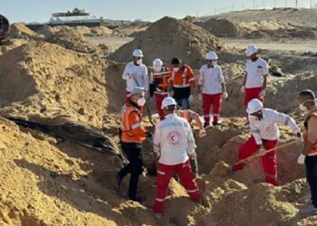 Equipes do Crescente Vermelho e da Defesa Civil palestina escavam em vala comum em busca de corpos dos socorristas (Jonatthan Whittall/X)
