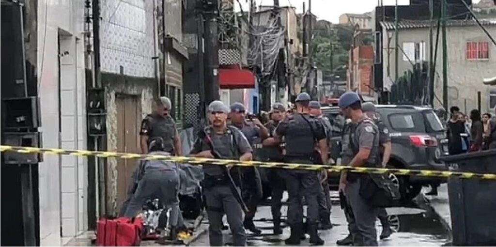 Corpo do adolescente à esquerda do cordão policial. Mais uma vítima da Operação Escudo - Foto: Divulgação