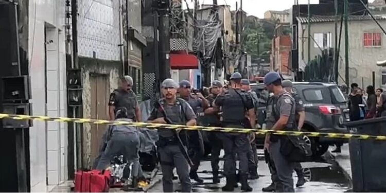 Corpo do adolescente à esquerda do cordão policial. Mais uma vítima da Operação Escudo - Foto: Divulgação