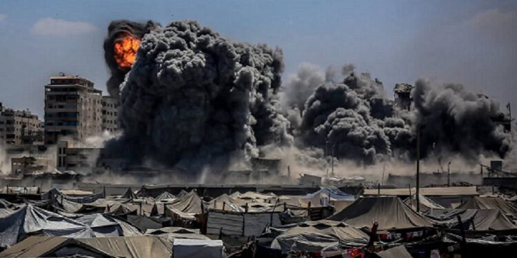 Cercado por tendas de palestinos desabrigados, mais um edifício bem abaixo sob bombas despejadas por Israel Foto: Reprodução/Internet Cercado por tendas de palestinos desabrigados, mais um edifício bem abaixo sob bombas despejadas por Israel Foto: Reprodução/Internet