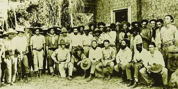 Sentado, Luiz Carlos Prestes é o quarto da esquerda para a direita. Membros da Coluna Prestes - Acervo Luiz Carlos Prestes Filho.
Sentado, Luiz Carlos Prestes é o quarto da esquerda para a direita. Membros da Coluna Prestes - Acervo Luiz Carlos Prestes Filho.